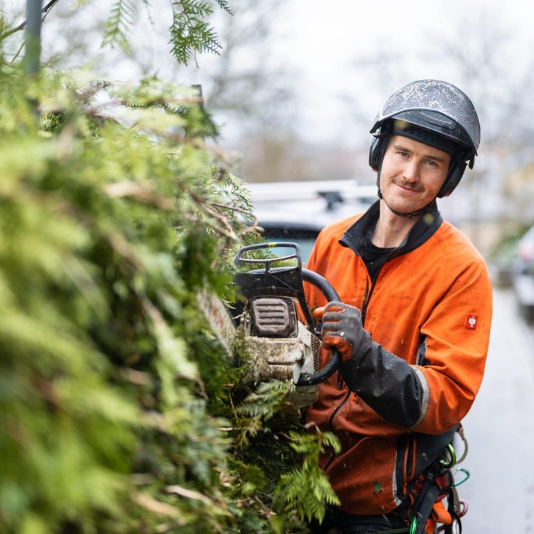 Finn Stamm bei der Fensterreinigung von außen am Gebäude, mit Helm und im Seil hängend